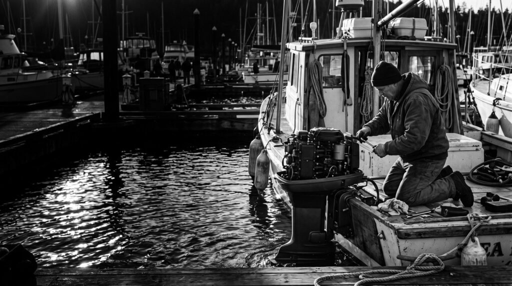 A marine technician servicing an outboard motor at a marina dock